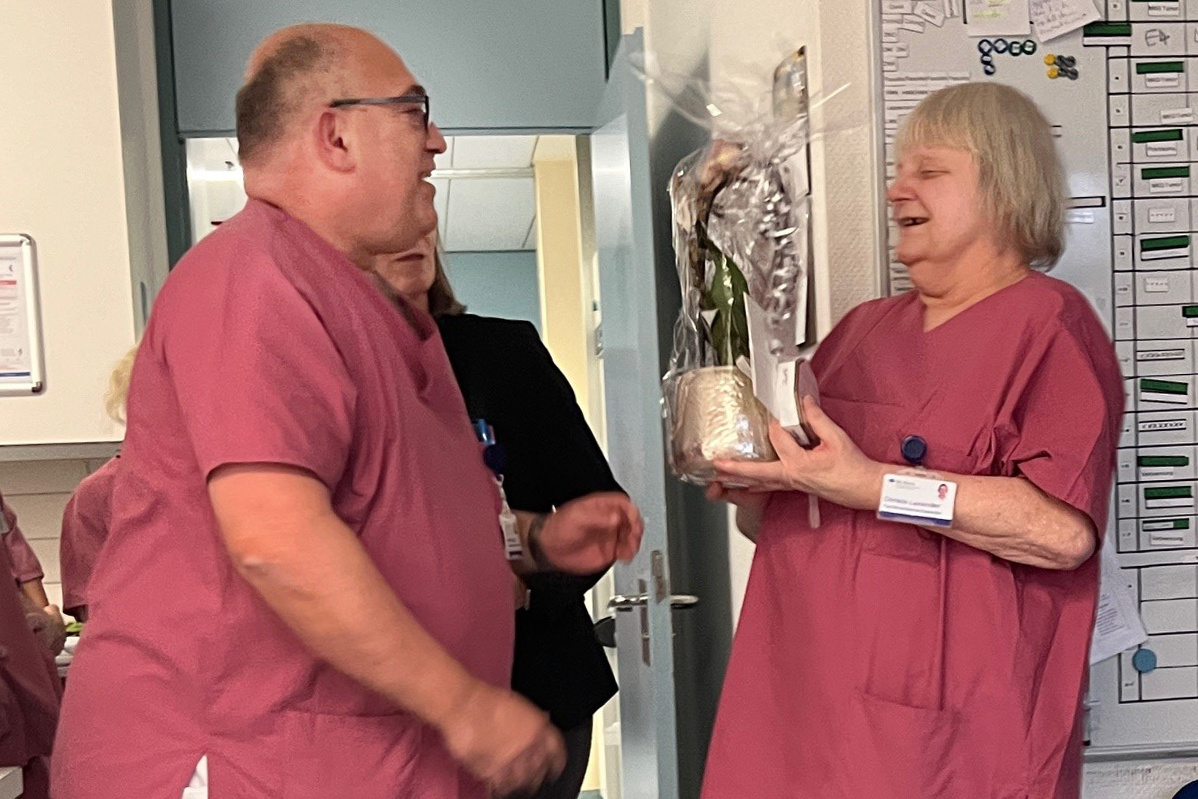 Stv. Pflegedirektor Robert Lippert überreicht Christa Laxander einen Blumenstrauß.
