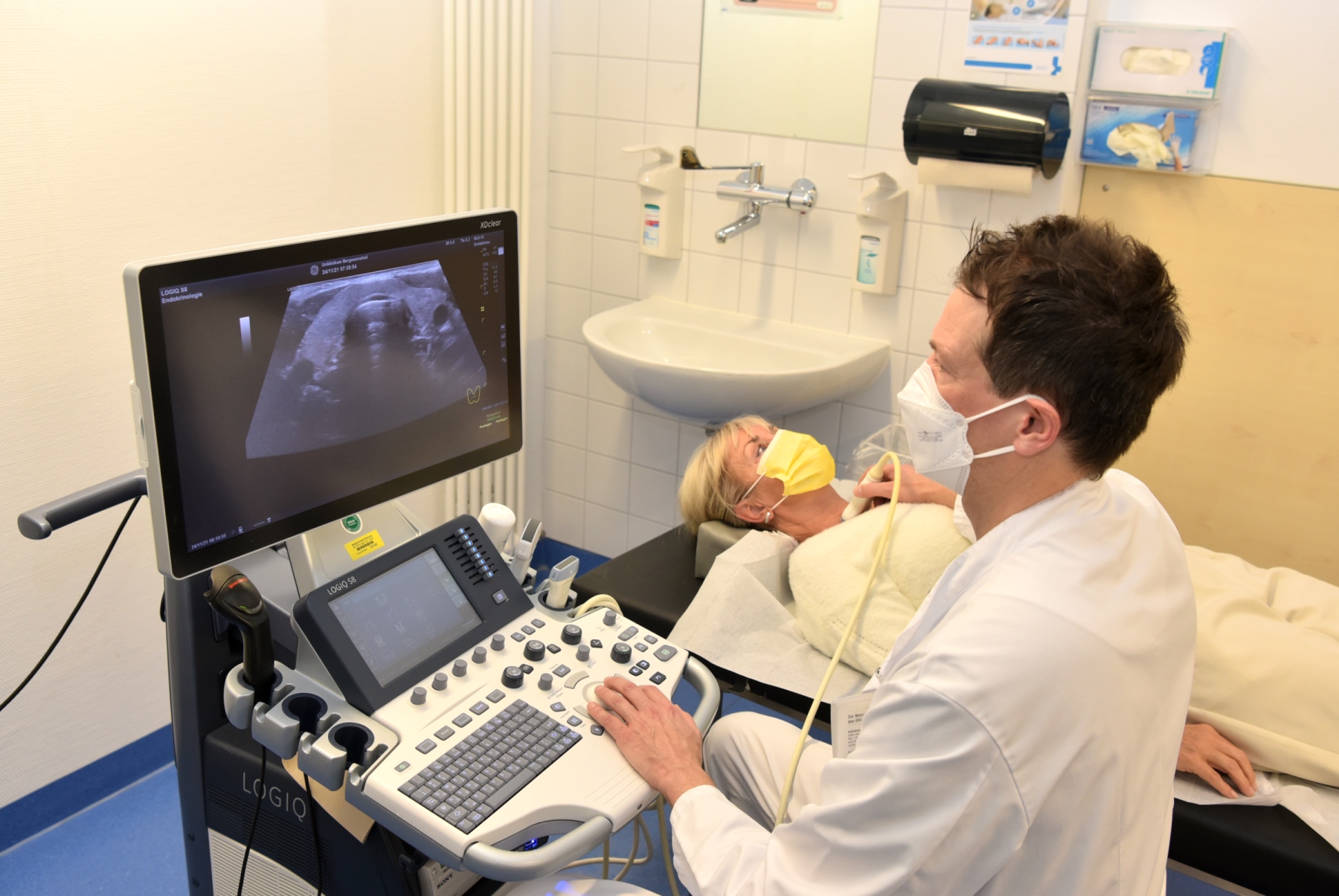 Arzt führt Ultraschalluntersuchung bei einer Patientin durch.