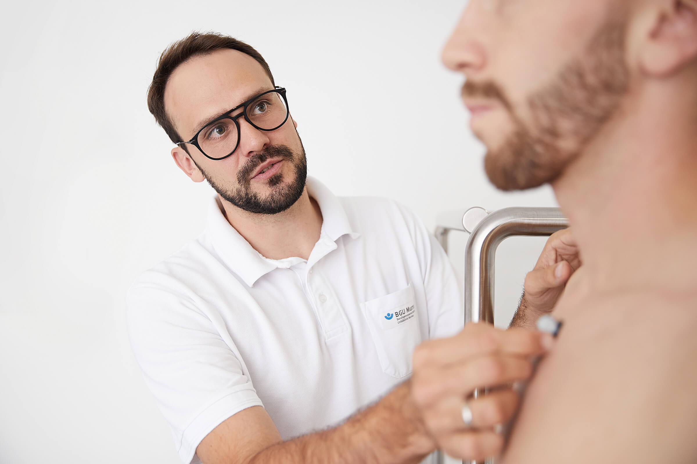 Ein Arzt horcht mit einem Stethoskop die Brust eines Patienten ab