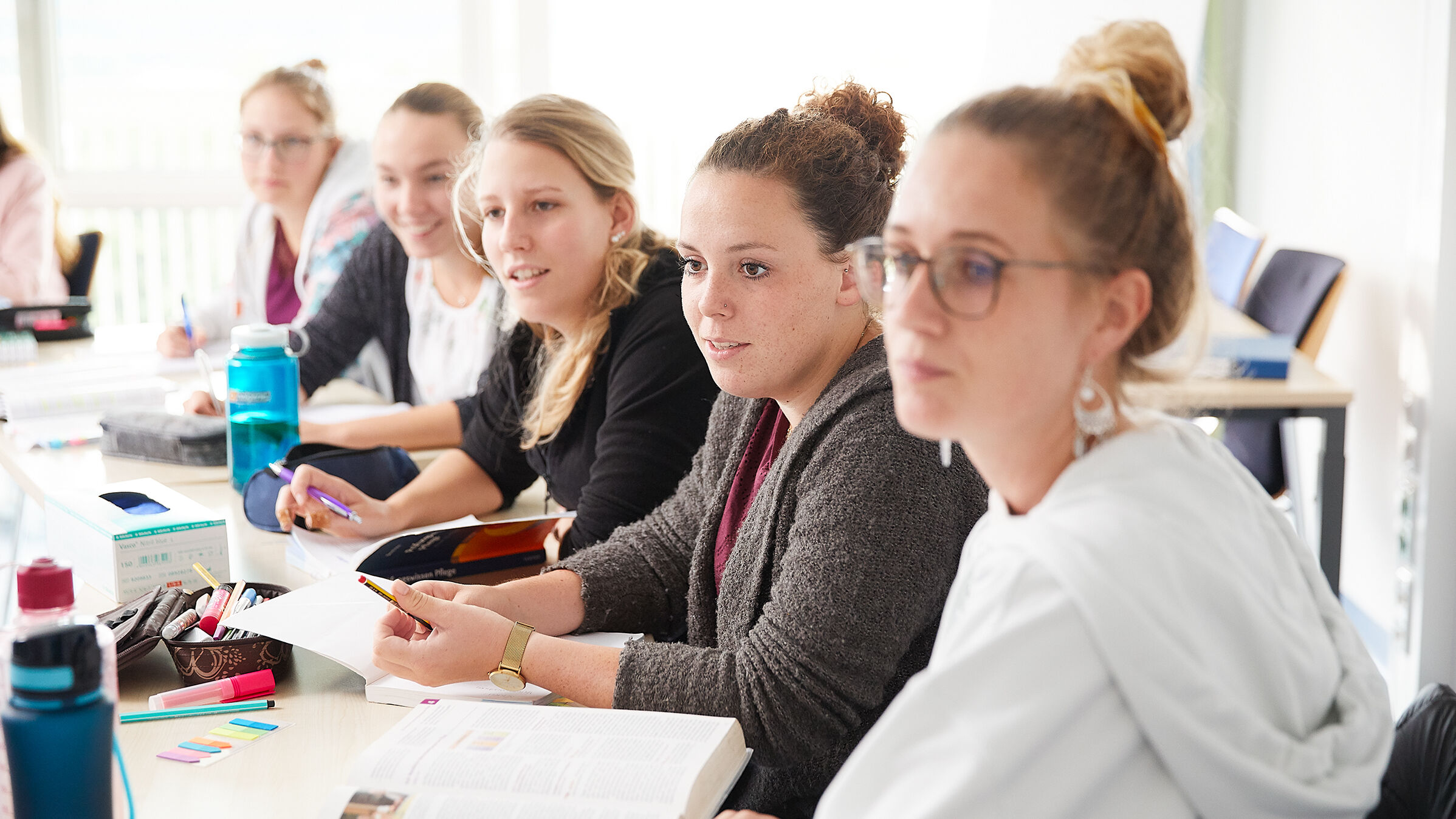 Fünf Schülerinnen sitzen im Klassenraum