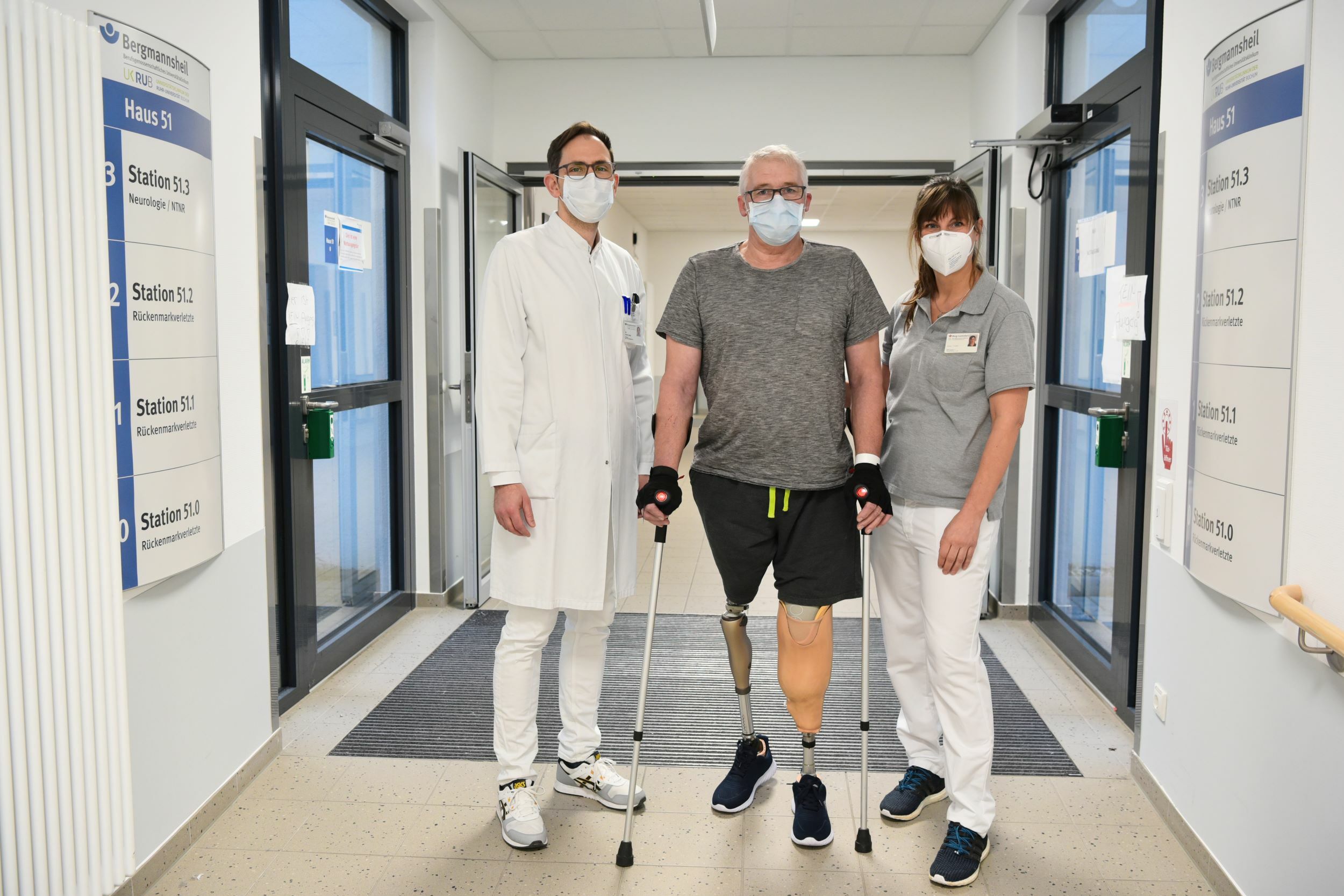 Patient Werner Stähler mit Arzt und Therapeutin nach beidseitiger Amputation