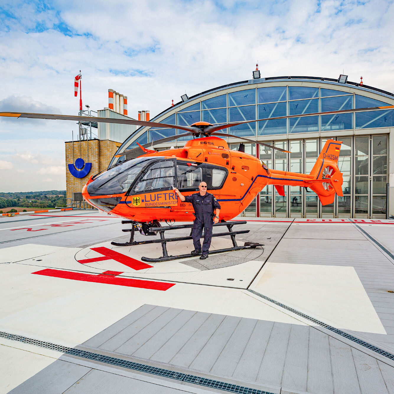 Hubschrauber und Pilot auf Dachlandeplatz Hubschrauber und Pilot auf Dachlandeplatz