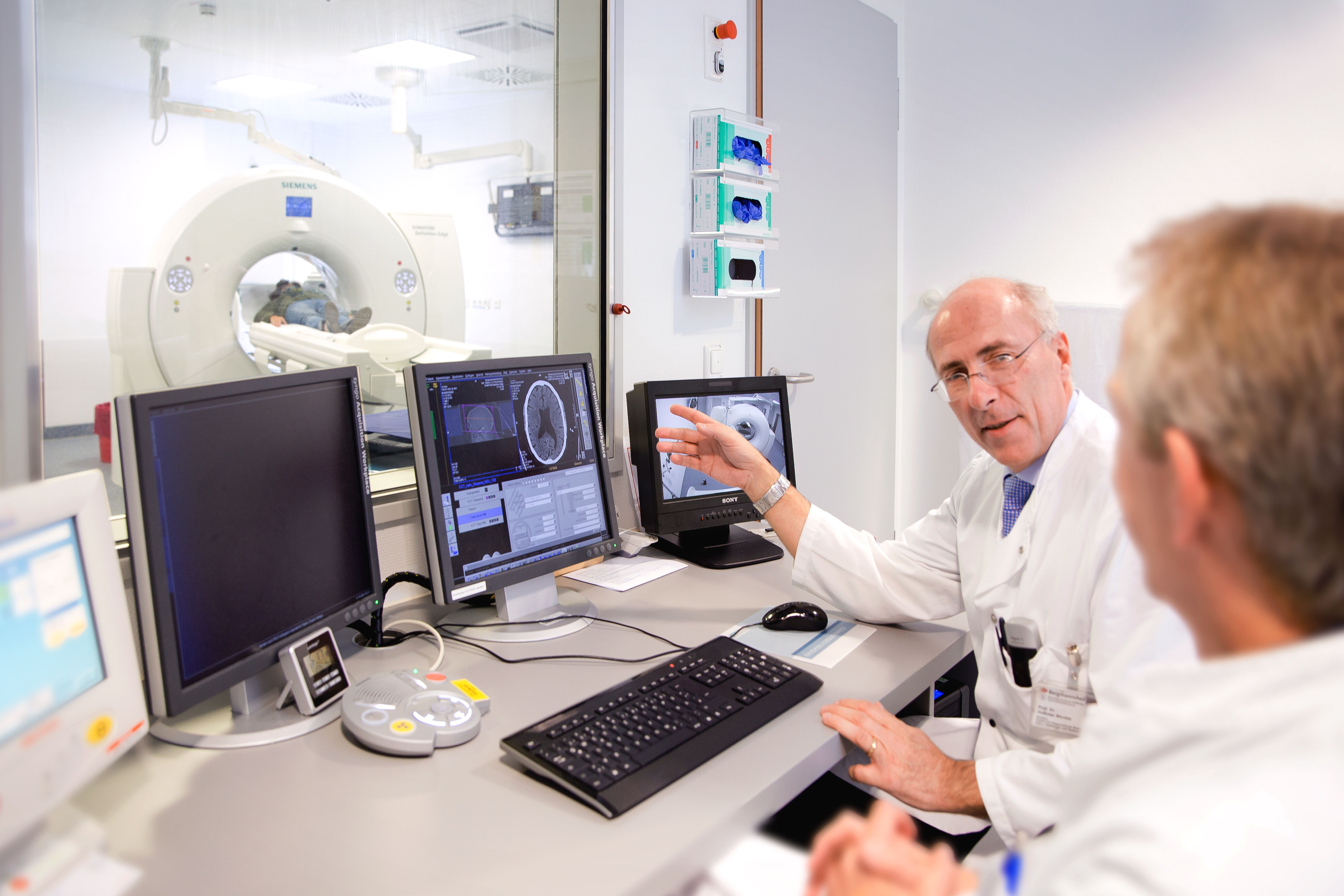 Besprechung MRT-Aufnahmen eines Patienten Zwei Ärzte besprechen die MRT-Aufnahmen eines Patienten
