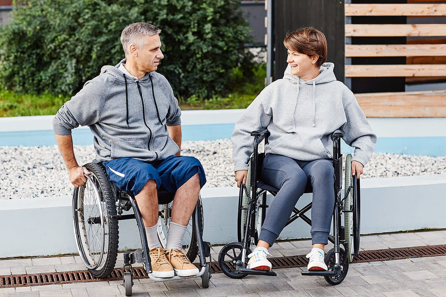 Ein Mann und eine Frau im Rollstuhl im Gespräch