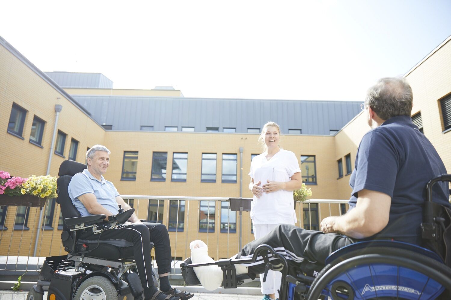 Zwei Patienten im Rollstuhl vor dem BG Klinikum Bergmannstrost Halle