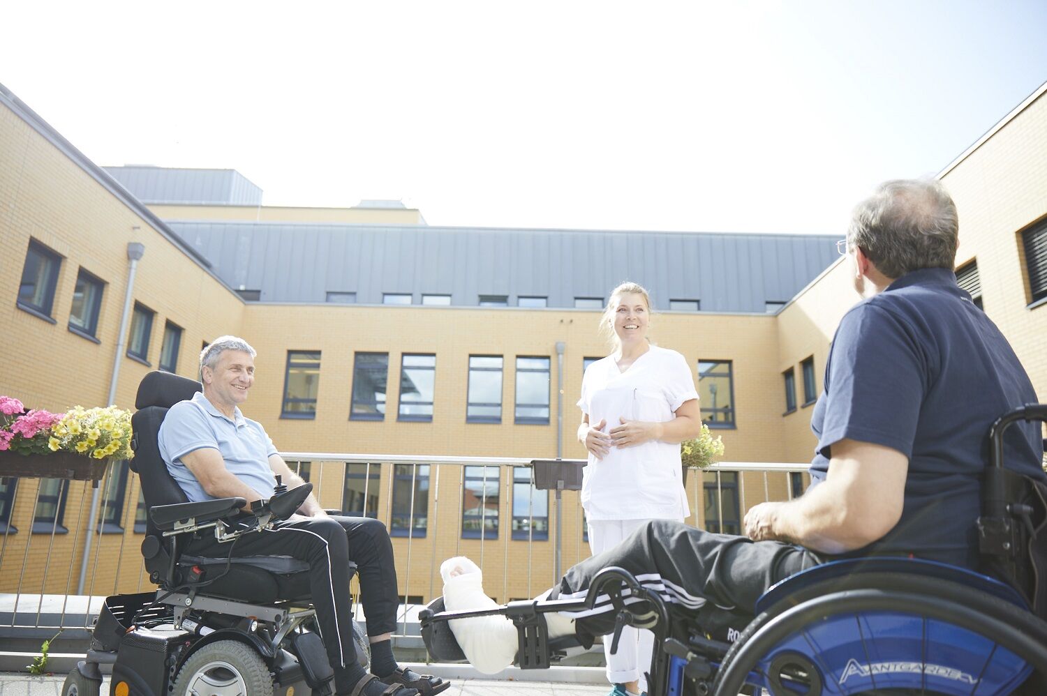 25 Jahre Zentrum für Rückenmarkverletzte am Bergmannstrost Zwei Patienten im Rollstuhl vor dem BG Klinikum Bergmannstrost Halle