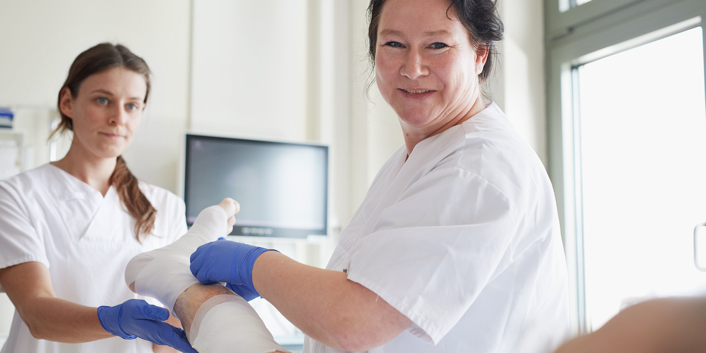 Zwei Pflegekräfte am Patientenbett