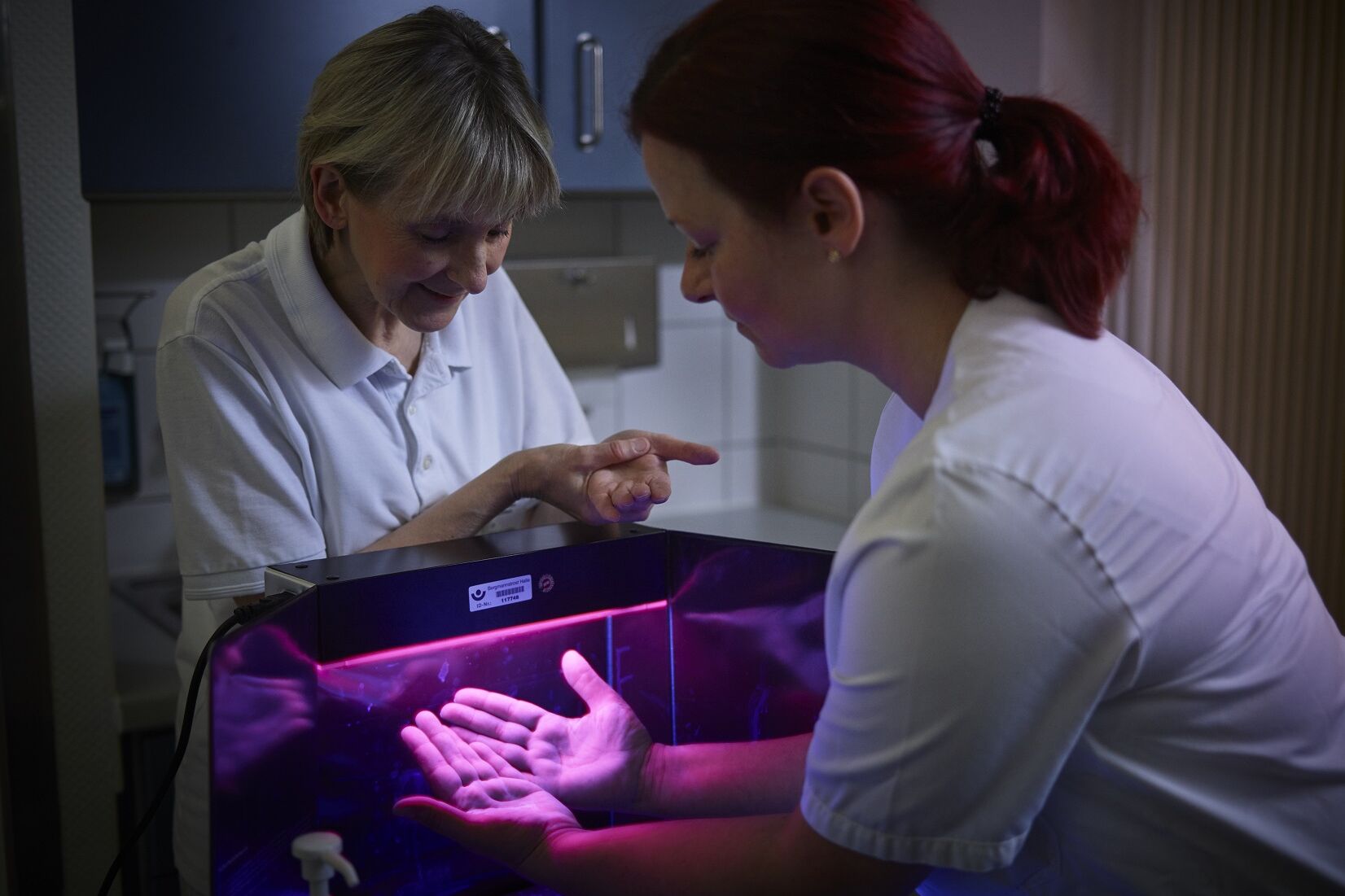 Zwei Frauen beim Hygiene-Test mit der UV Schwarzlichtlampe