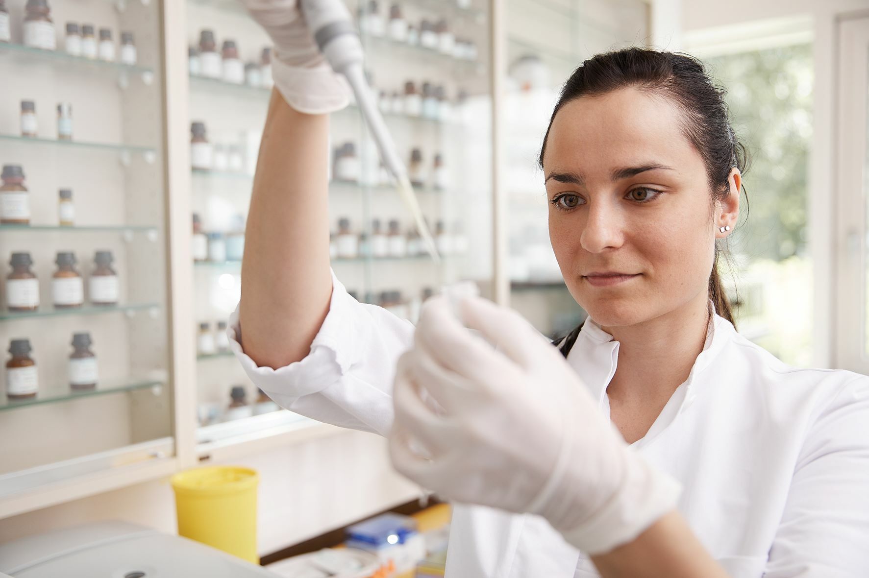 Innovative Diagnostik und Therapien Eine Mitarbeiterin pipettiert eine Flüssigkeit in ein Gefäß