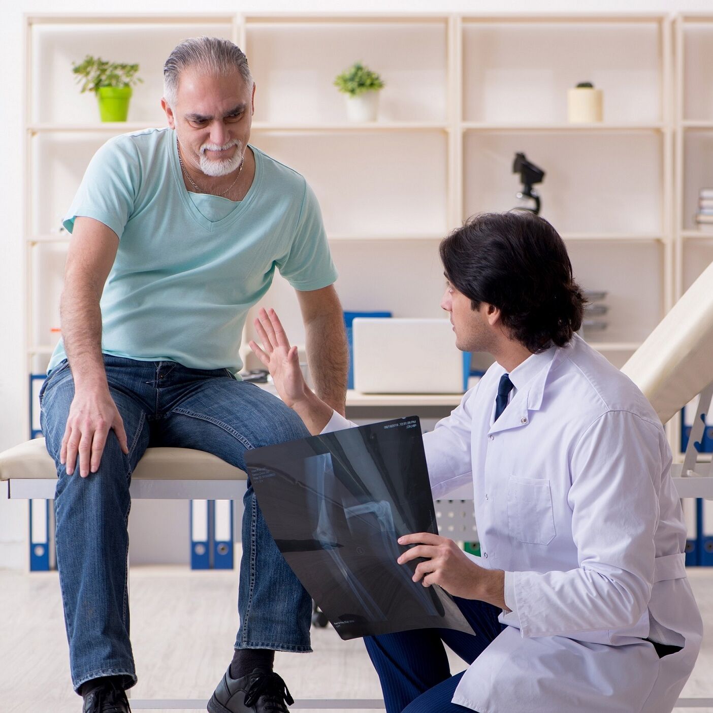 Ein Arzt berät einen Patienten anhand eines Röntgenbildes