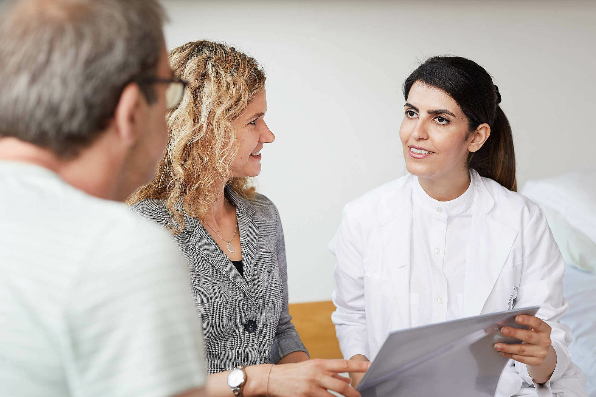 Eine Ärztin und eine Reha-Managerin beraten einen Patienten