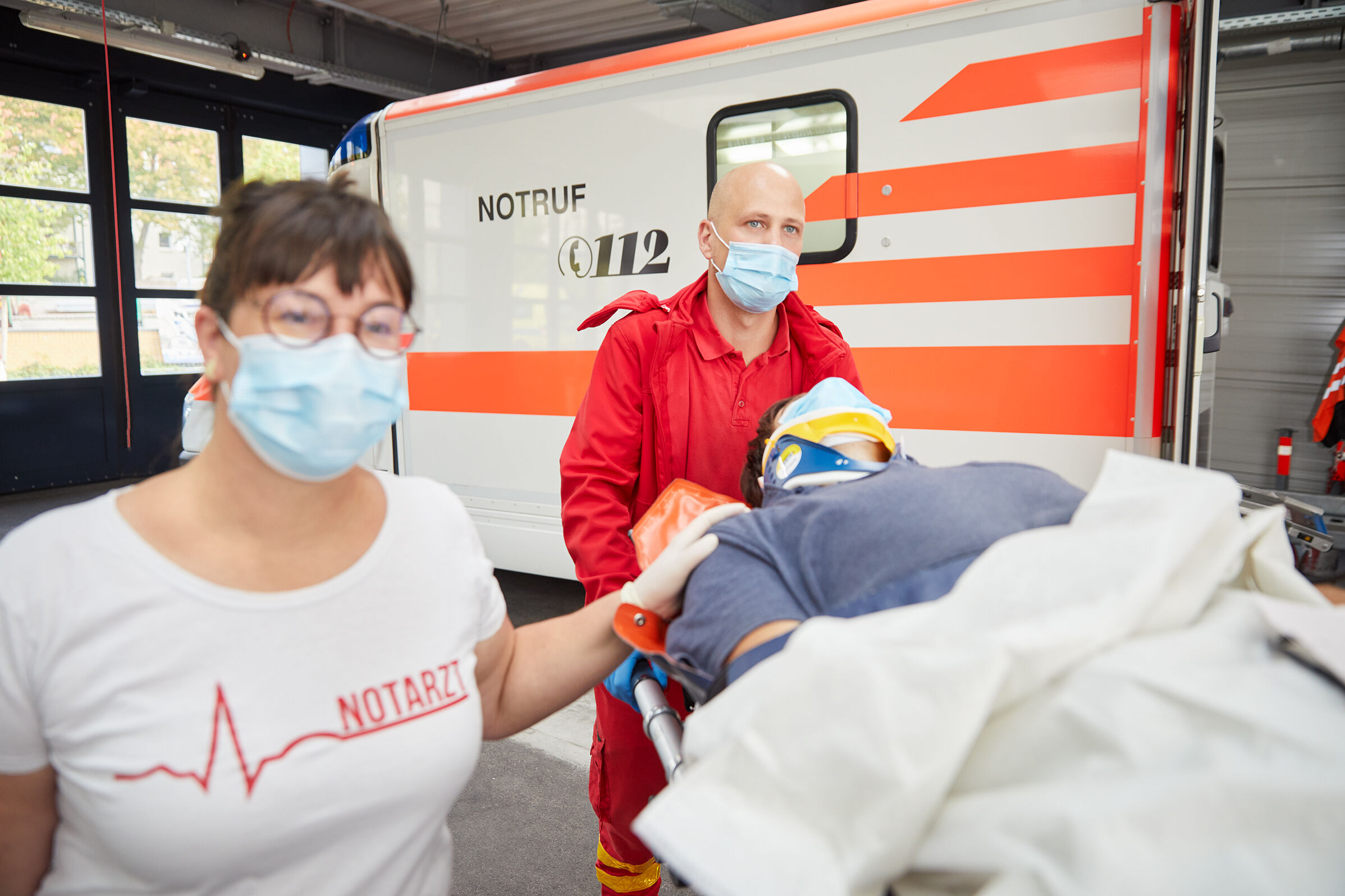 Eva Handschuh und Sanitäter mit Patient am Notarztwagen