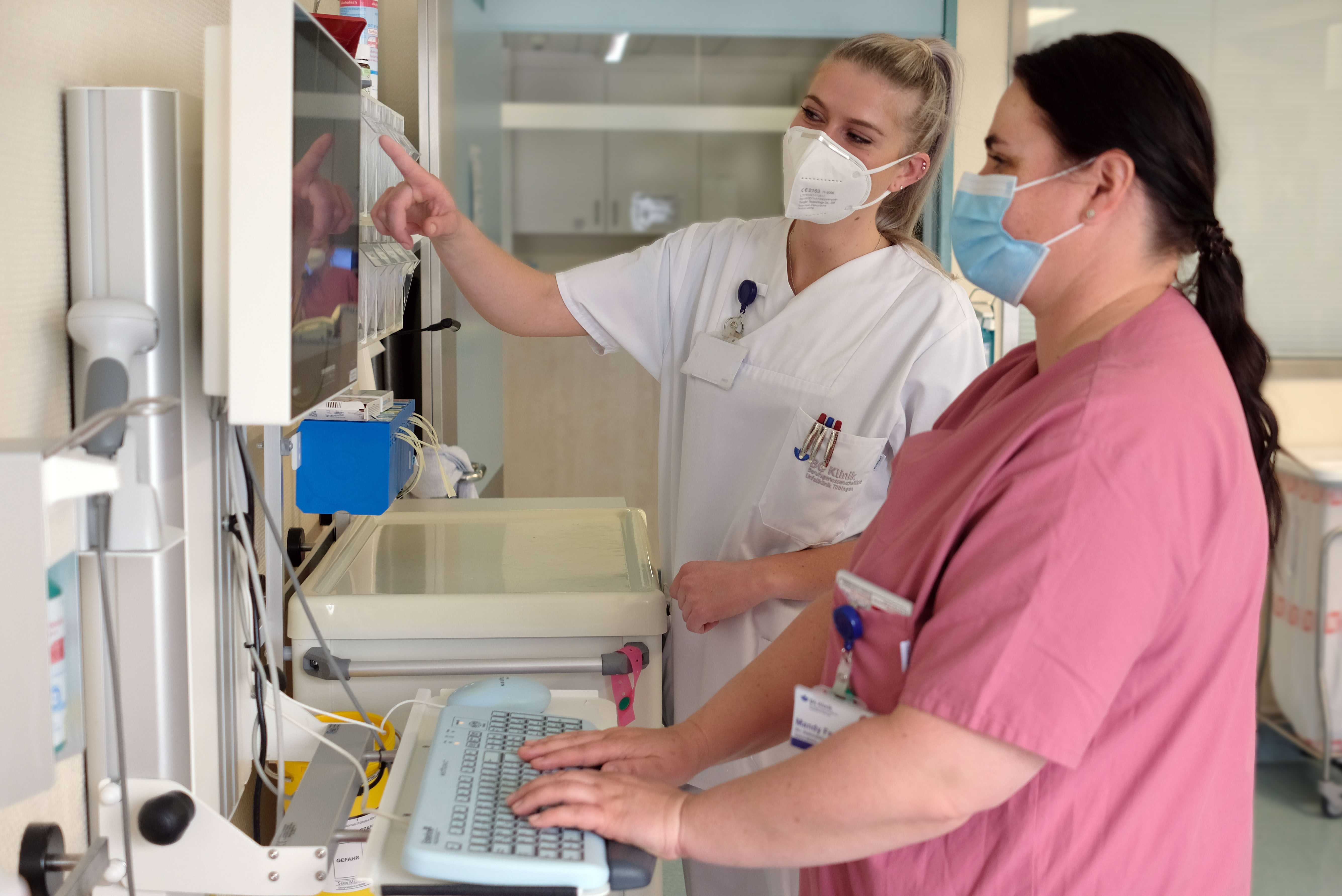 Moderne Ausstattung auf der Intensivstation: Azubi Milena Reinhardt und ihre Praxisanleiterin besprechen die auf dem Monitor angezeigten Vitalzeichen des Patienten.
