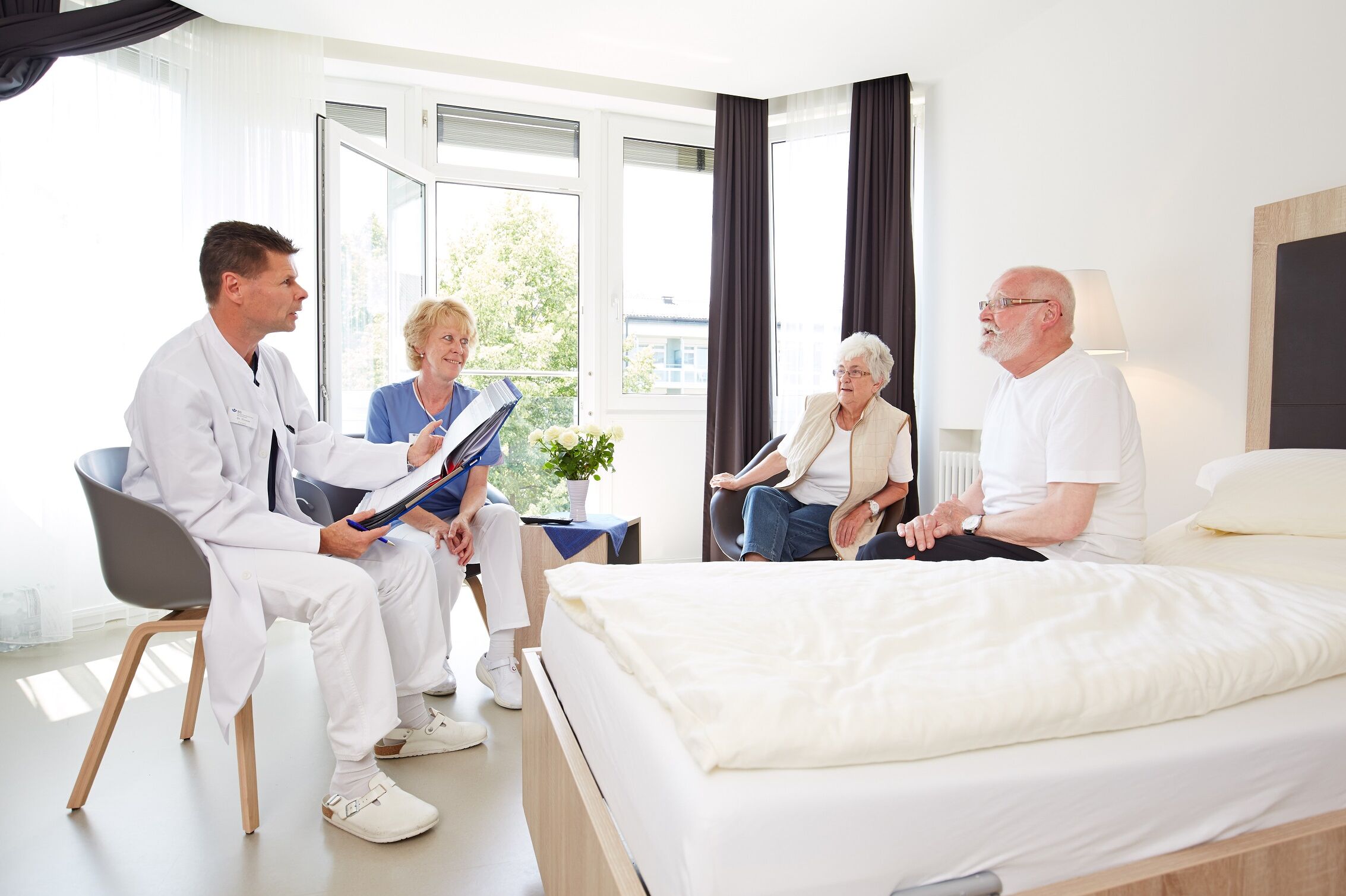 Patienten Ein Arzt und eine Pflegekraft beraten einen Patienten und seine Begleitung