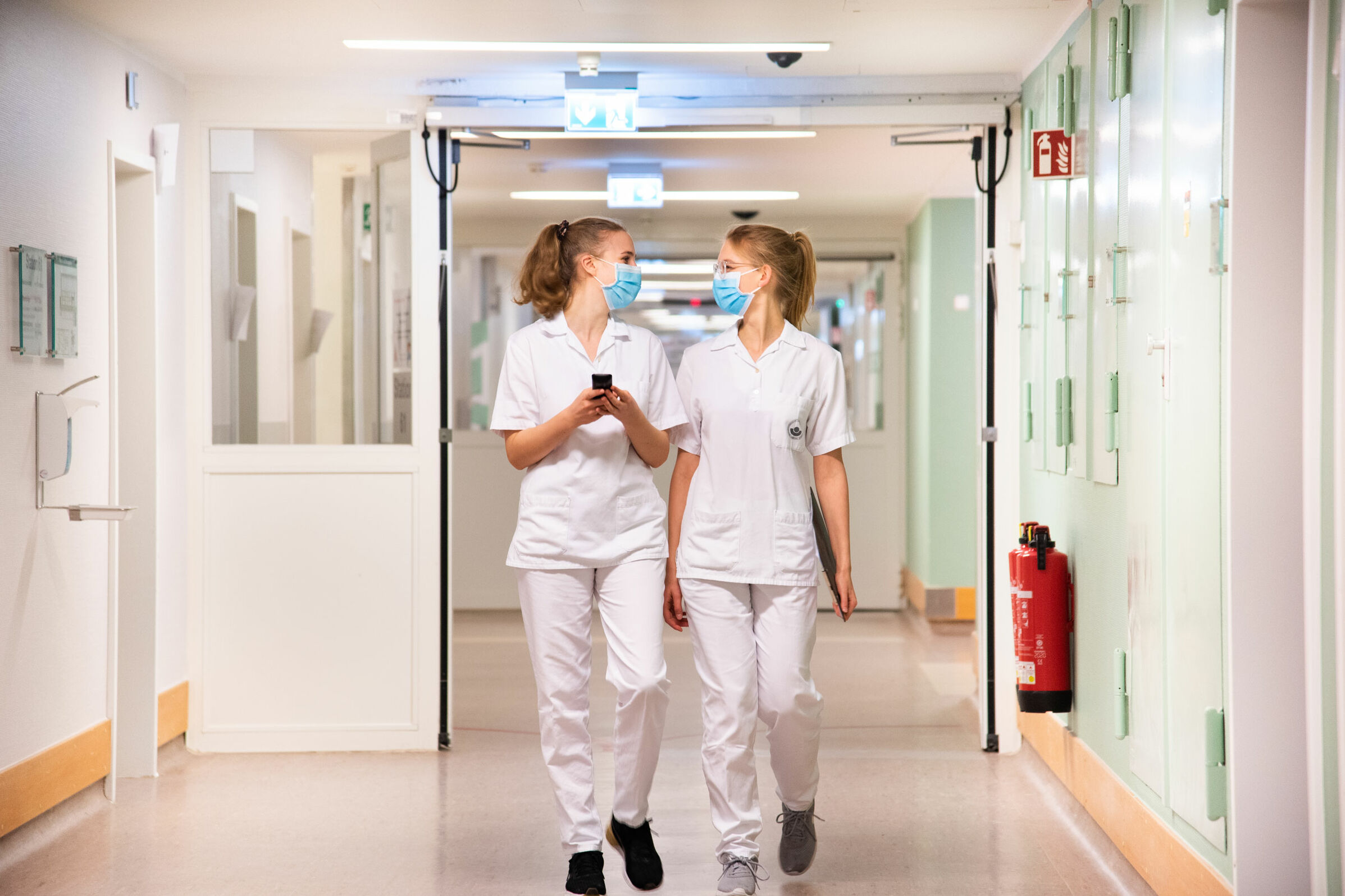 Zwei Pflegeschülerinnen laufen im Gang des Klinikums