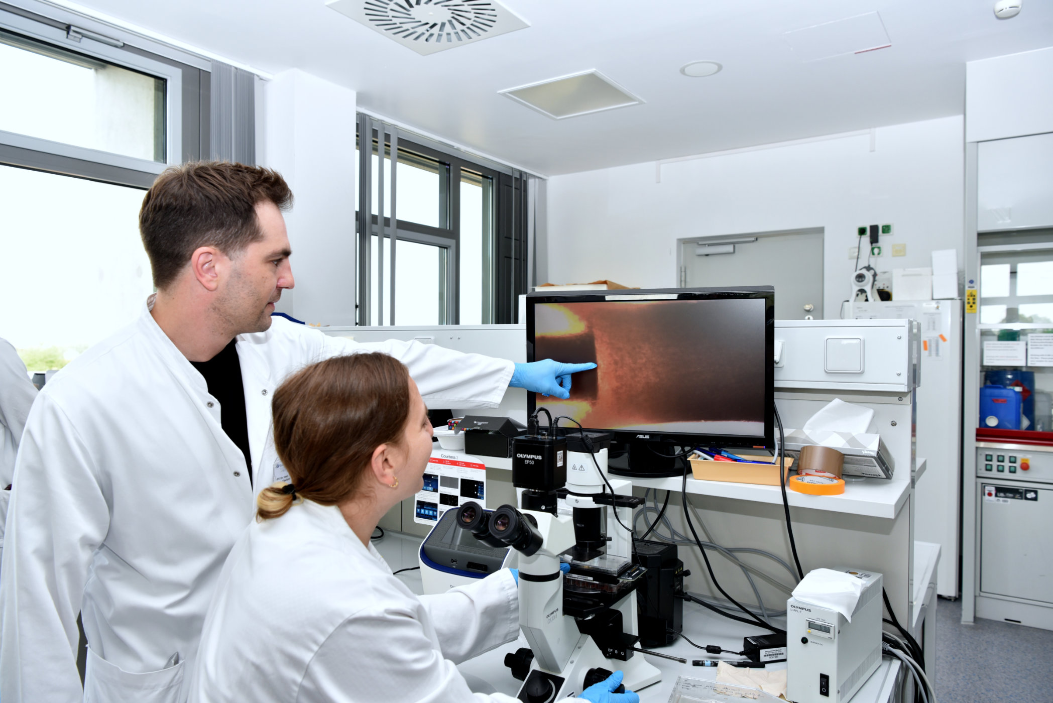 PD Dr. Felix Kleefeld mit Dr. Nassam Daya zeigen eine mikroskopische Vergrößerung eines Muskelorganoids. Bildnachweis: Bergmannsheil