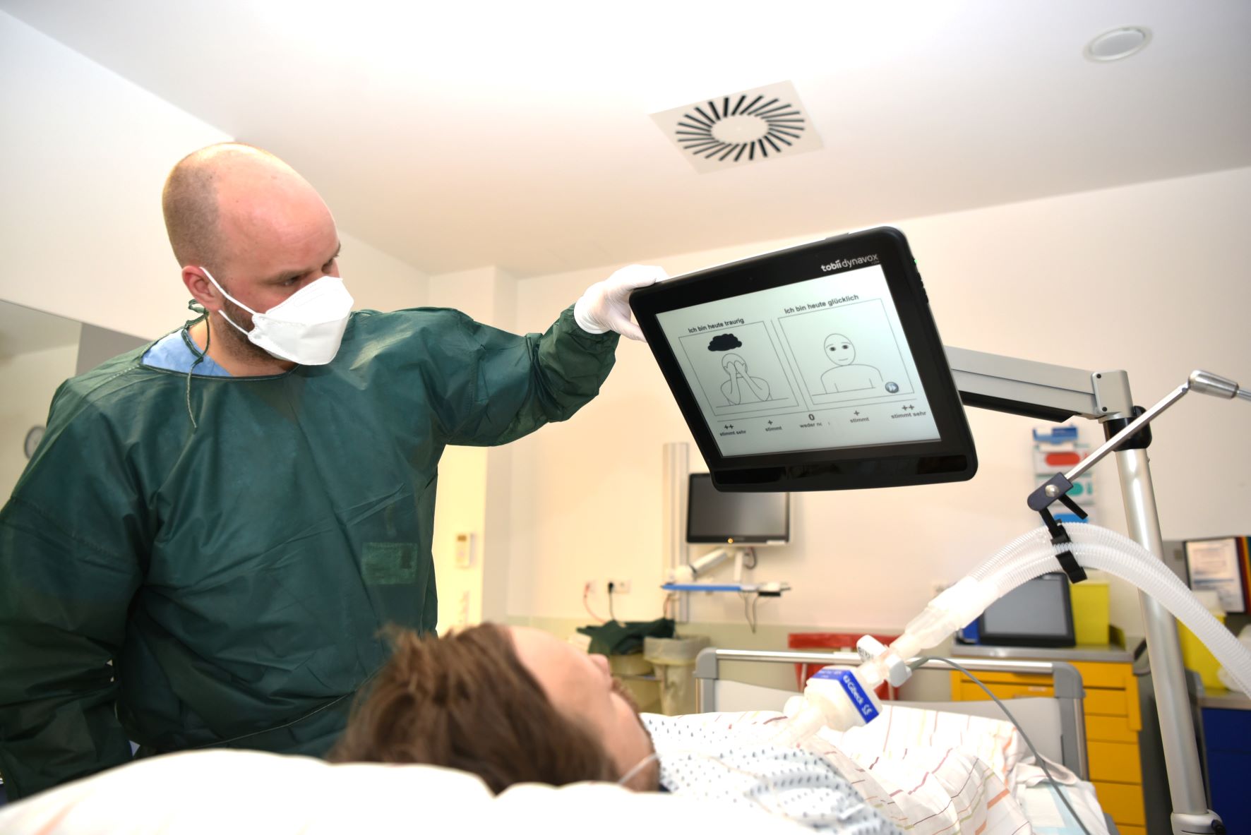 Intensivpfleger kommuniziert via Eye-Tracking-System mit einer Patientin