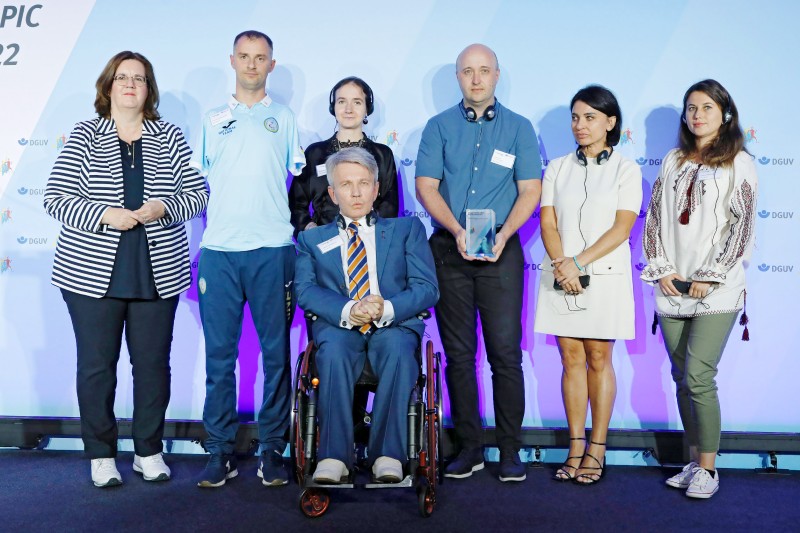 v.l.n.r: Kerstin Griese (Parl. Staatssekretärin im BMAS) mit Semenenko Yaroslav, paralympischer Schwimmer, dem Präsidenten des paralympischen Komitees der Ukraine, Valerii Sushkevych sowie der ukrainischen Delegation. (Foto: Jan Röhl / DGUV) v.l.n.r: Kerstin Griese (Parl. Staatssekretärin im BMAS) mit Semenenko Yaroslav, paralympischer Schwimmer, dem Präsidenten des paralympischen Komitees der Ukraine, Valerii Sushkevych sowie der ukrainischen Delegation. (Foto: Jan Röhl / DGUV)